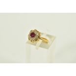 A YELLOW METAL RUBY AND DIAMOND CLUSTER RING, of a circular form, centring on a four claw set,