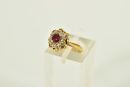 A YELLOW METAL RUBY AND DIAMOND CLUSTER RING, of a circular form, centring on a four claw set,