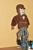A MODERN CARVED WOODEN MARIONETTE OF A MAN ON A UNICYCLE, understood to be French, appears