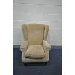 A PARKER KNOLL BEIGE UPHOLSTERED WING BACK ARMCHAIR, on turned legs and brass casters