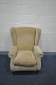 A PARKER KNOLL BEIGE UPHOLSTERED WING BACK ARMCHAIR, on turned legs and brass casters