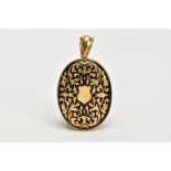 A VICTORIAN YELLOW METAL ENAMEL MOURNING LOCKET, of an oval form, decorated with a foliate gold