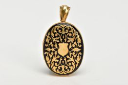 A VICTORIAN YELLOW METAL ENAMEL MOURNING LOCKET, of an oval form, decorated with a foliate gold