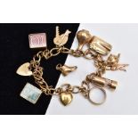 A 9CT GOLD CHARM BRACELET, curb link bracelet suspending ten charms in forms such as a lamp,