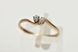 A 9CT GOLD DIAMOND RING, of a cross over design, set with two claw set round brilliant cut diamonds,