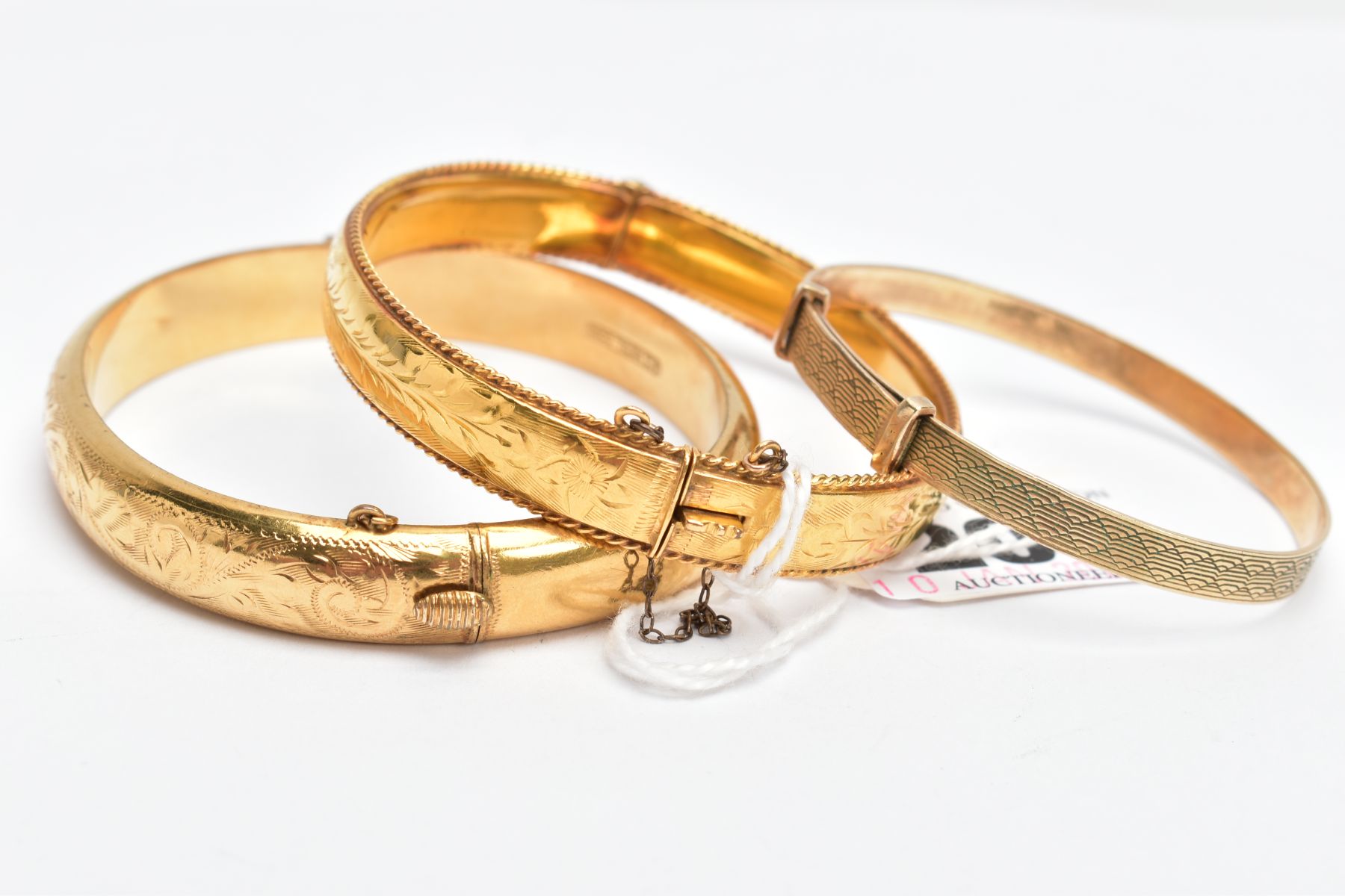 THREE YELLOW METAL BRACELETS, a floral hinged bangle with a rope twist edge, fitted with a push - Image 3 of 3
