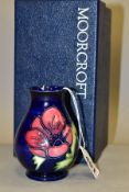 A BOXED MOORCROFT POTTERY VASE, baluster shaped vase with tube lined anemone pattern on a dark