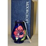 A BOXED MOORCROFT POTTERY VASE, baluster shaped vase with tube lined anemone pattern on a dark