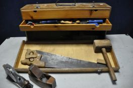 A VINTAGE WOODEN TOOLBOX containing a selection of woodworking tools chisels, hammer, planes etc