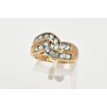 A 9CT GOLD GEM SET RING, of a cross over design, with two rows of channel set, circular cut
