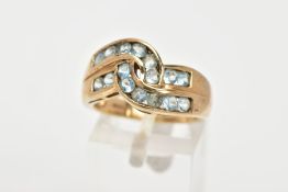 A 9CT GOLD GEM SET RING, of a cross over design, with two rows of channel set, circular cut