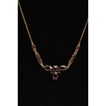 A YELLOW METAL GARNET NECKLACE, set with circular and pear cut garnets, fitted to a fine curb link