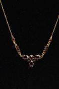 A YELLOW METAL GARNET NECKLACE, set with circular and pear cut garnets, fitted to a fine curb link