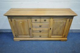 A SOLID GOLDEN OAK SIDEBOARD, a bank of four long drawers flanked by two cupboard doors enclosing