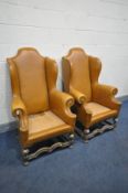 A PAIR OF EARLY 20TH CENTURY QUEEN ANNE STYLE TAN LEATHERETTE WING BACK ARMCHAIRS, on a carved oak