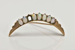 A YELLOW METAL CRESCENT OPAL BROOCH, a yellow metal brooch set with seven oval opal cabochons (