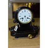 A VICTORIAN EBONISED MANTEL CLOCK, the balloon shaped case flanked to each side by carved