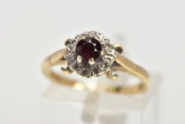 A 9CT GOLD GARNET AND DIAMOND CLUSTER RING, raised cluster centring on a circular cut garnet, within