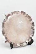 A SILVER SALVER, circular design with a wavy rim, raised on four hoof feet, approximate width 25.