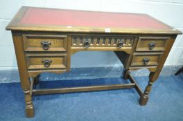 AN OLD CHARM STYLE OAK DESK, with a red leather and gilt tooled inlay top, and five drawers, width