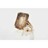 A YELLOW METAL SMOKEY QUARTZ RING, designed with a four claw set, rectangular cut smokey quartz with