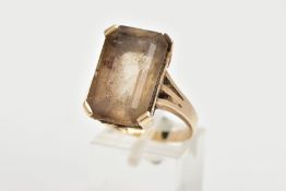 A YELLOW METAL SMOKEY QUARTZ RING, designed with a four claw set, rectangular cut smokey quartz with