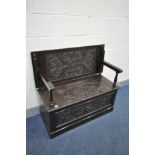 AN EARLY 20TH CENTURY CARVED OAK MONKS BENCH, with foliate decoration and carved mask to the front