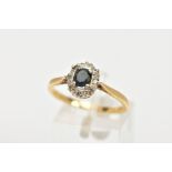 AN 18CT GOLD SAPPHIRE AND DIAMOND CLUSTER RING, centring on a four claw set, oval cut blue sapphire,