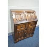 AN OAK LINENFOLD BUREAU, with a single drawer, width 76cm x depth 43cm x height 100cm (key)