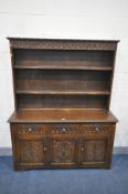 A 20TH CENTURY CARVED OAK DRESSER, the top with a double plate rack, on a base with three drawers