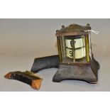 AN EDWARDIAN BRASS AND LEATHER CASED PERPETUAL CALENDAR, in an architectural case, lacks finial, the