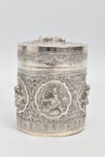 A WHITE METAL POT, embossed with south Asian artwork, the pot with a removable lid depicts two