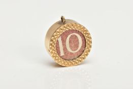 A 9CT GOLD MONEY CHARM, of a circular form inset with a ten shilling banknote, hallmarked 9ct gold