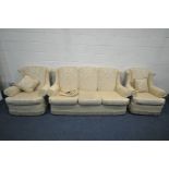 A GOLD UPHOLSTRED THREE PIECE SUITE, comprising a three seater settee, length 192cm, and a pair of