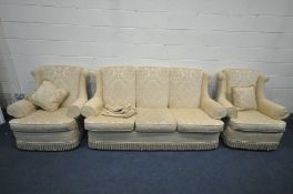A GOLD UPHOLSTRED THREE PIECE SUITE, comprising a three seater settee, length 192cm, and a pair of
