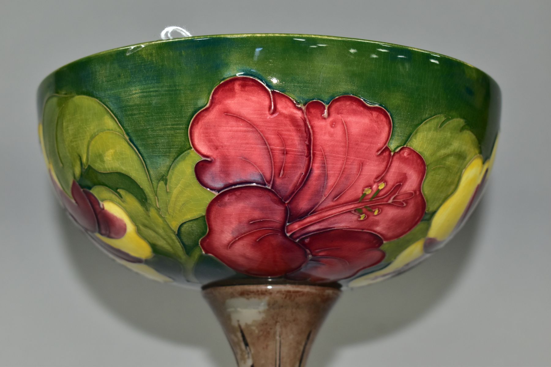 A MOORCROFT POTTERY BOWL DECORATED WITH RED AND YELLOW HIBISCUS ON A GREEN GROUND, the interior of - Image 5 of 6