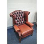 A RED LEATHER BUTTON BACK WINGED ARMCHAIR with cabriole front legs (condition:- some fading to