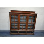 AN EARLY 20th CENTURY TRIPLE DOOR WALNUT GLAZED BOOKCASE with raised back, carved central rail width