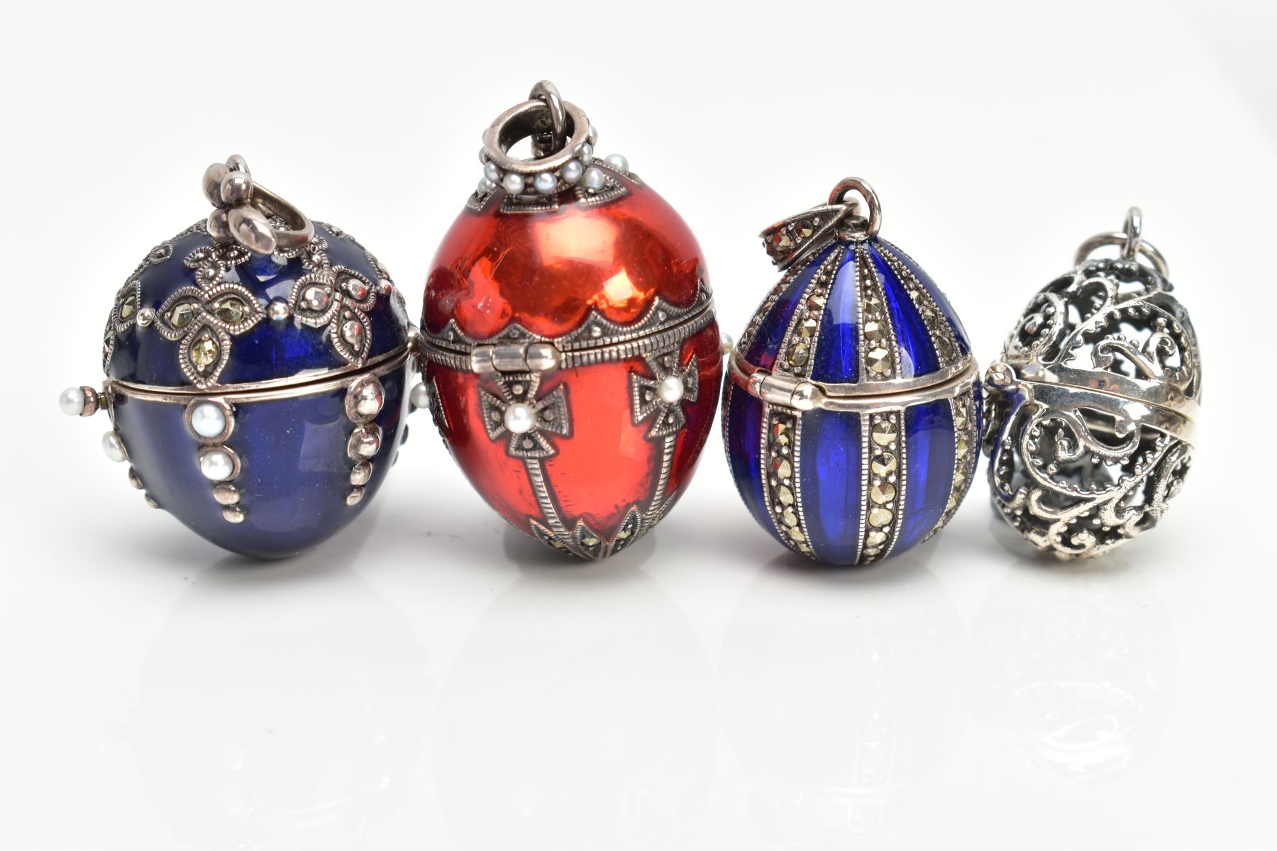 FOUR WHITE METAL AND ENAMEL EGG PENDANTS, to include a white metal openwork egg fitted with a - Image 2 of 5