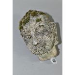 A RECONSITUTED STONE HEAD OF A BUDDHA, weathered and with moss coverage, some arears of damage,