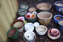 A LARGE QUANTITY OF GLAZED GARDEN PLANTERS including a graduated set of three green planters the