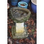 A MODERN COMPOSITE BIRD BATH with square brickwork effect base and a shaped top 30cm in diameter