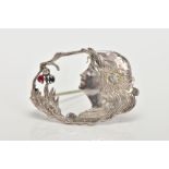 A SILVER ART NOUVEAU BROOCH, of an oval outline, designed as a woman in profile with flowers and
