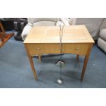 A MID CENTURY SEWING TABLE containing a Singer 538 sewing machine with power cable and foot pedal (