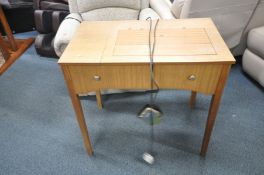 A MID CENTURY SEWING TABLE containing a Singer 538 sewing machine with power cable and foot pedal (