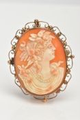 A SHELL CAMEO BROOCH, of an oval form, depicting a lady in profile facing right with flowers in