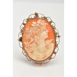 A SHELL CAMEO BROOCH, of an oval form, depicting a lady in profile facing right with flowers in