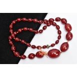 A CHERRY AMBER BAKELITE BEAD NECKLACE, graduated oval beads, largest measuring 25.4mm x 19.4mm,