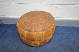 A VINTAGE LEATHER PATCHWORK POUFFE with etched panels, diameter 49cm (condition:- in good