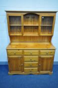 A PINE DRESSER, two central shelves flanked by two glazed cupboard doors, the base with six